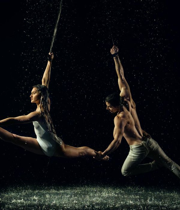 Woman performing a fluid cardio movement in a modern, dark studio.